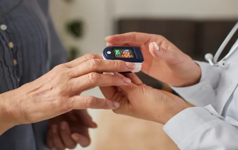 Clinician placing a pulse oximeter on a patient fingertip