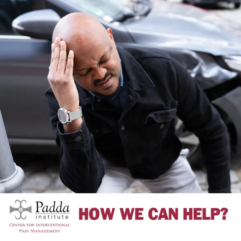 Man holding his head beside a damaged car after a collision