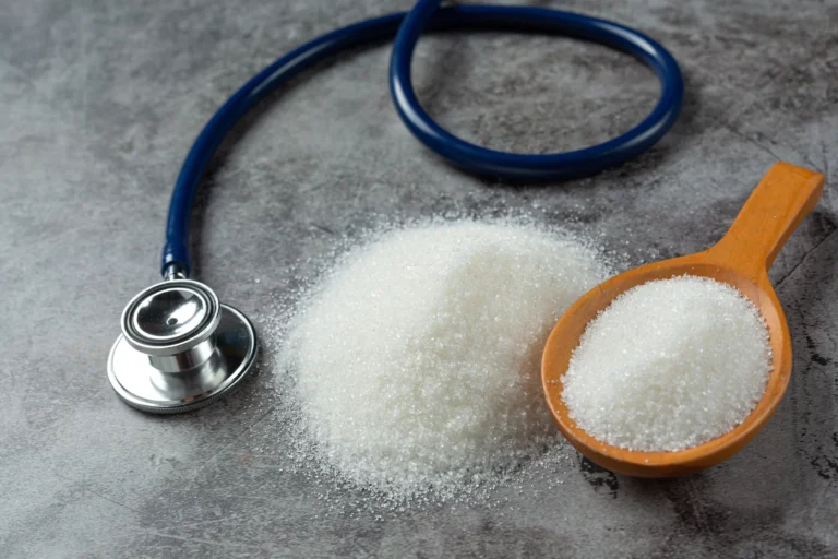 Stethoscope beside spilled white sugar and a wooden scoop