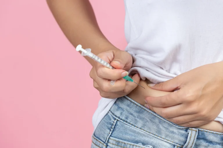 Person injecting insulin into the abdomen with a pen device