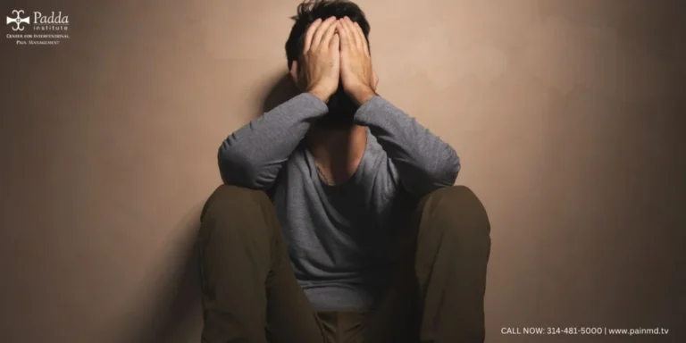Person sitting on the floor with head buried in both hands