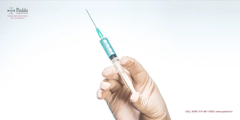 Gloved hand holding a filled syringe