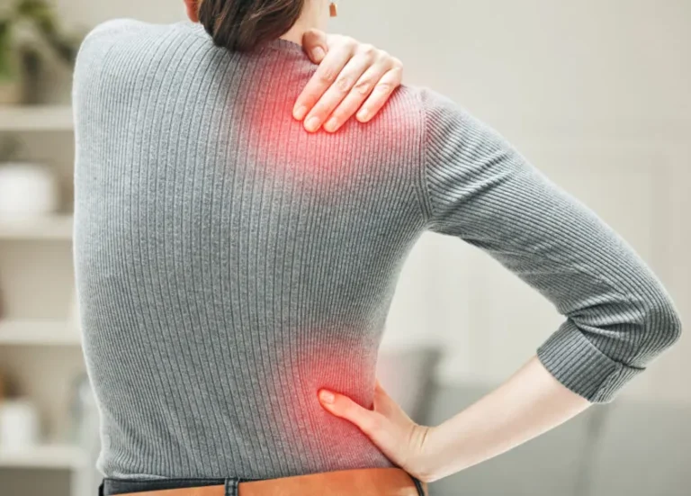 Back view of a woman with shoulder and upper back pain highlighted in red