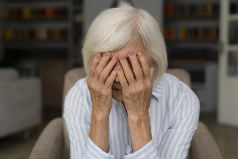 Older woman covering her face with both hands