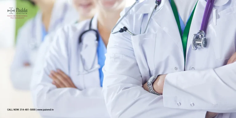 Group of doctors in white coats standing with arms folded