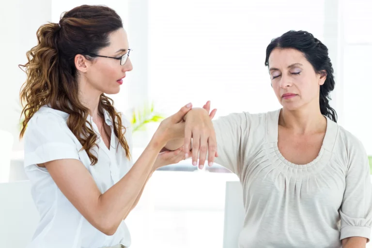 Clinician examining a womans wrist during an assessment