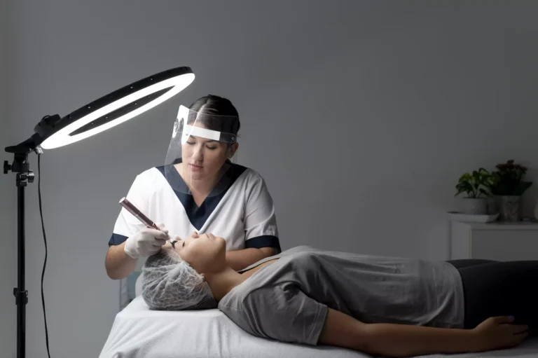 Clinician performing a procedure on a patient lying on a treatment couch