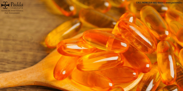 Orange fish oil capsules heaped on a wooden spoon
