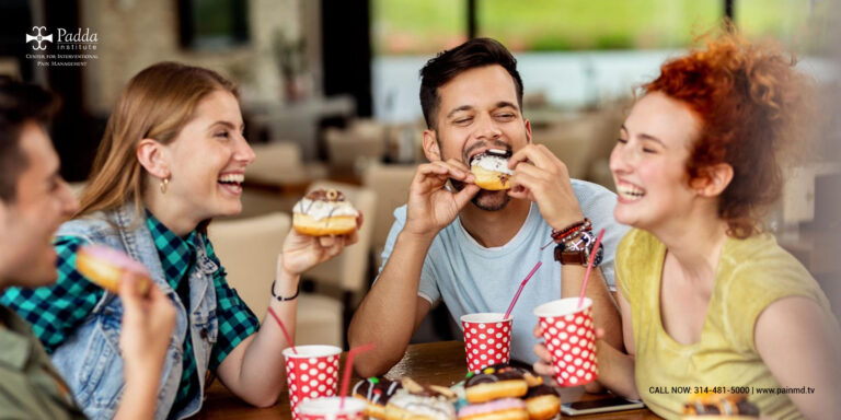 Group of young people eating doughnuts and fast food together