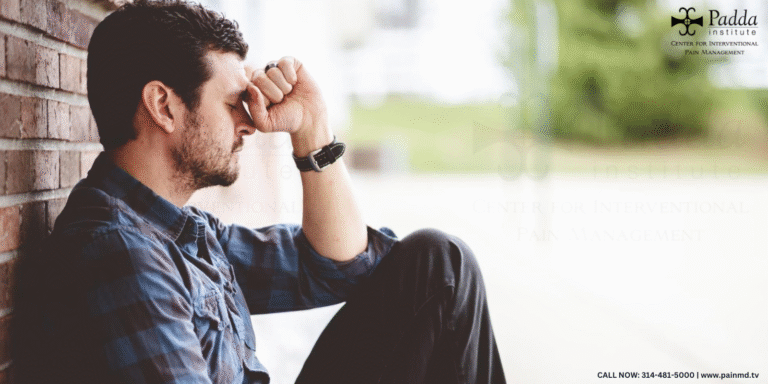 Man sitting outdoors resting his head against his hand