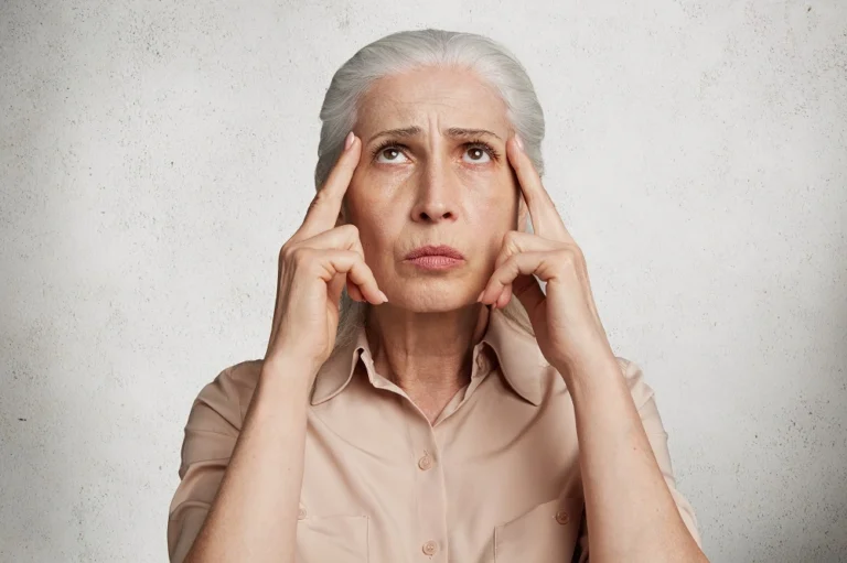 Older woman pressing her fingers to her temples
