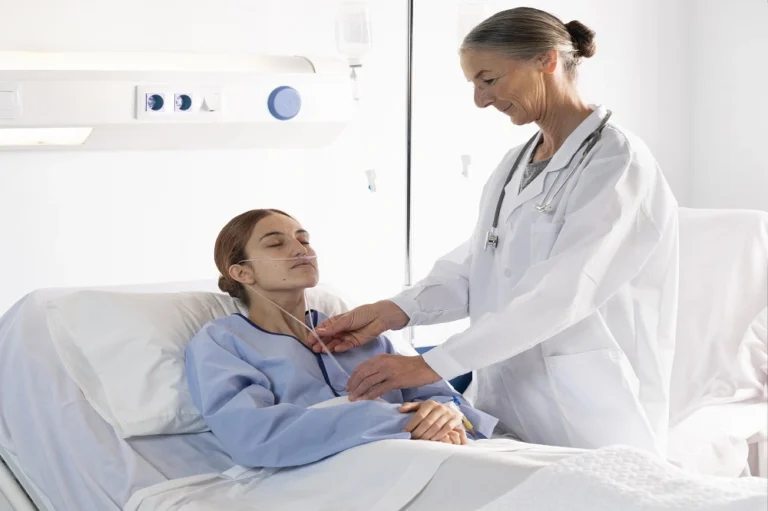 Clinician examining a patient lying in a hospital bed