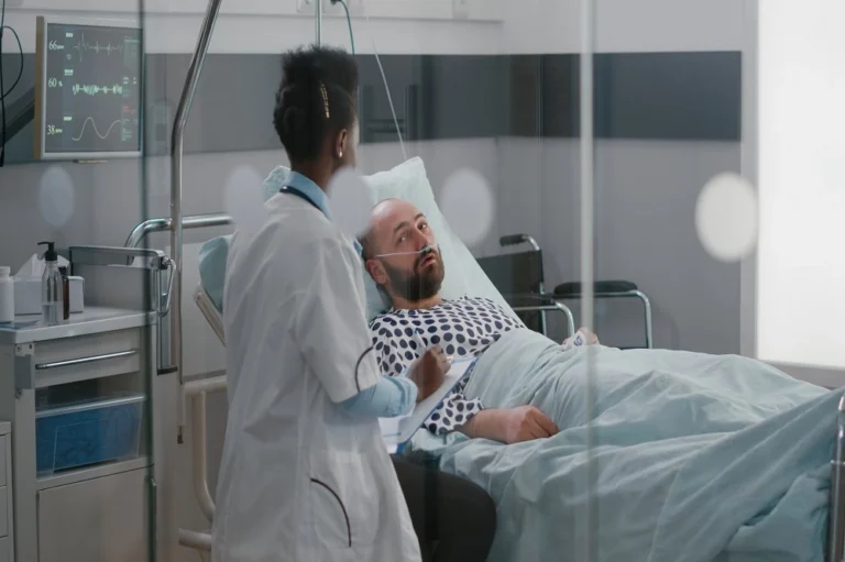 Doctor speaking with a patient lying in a hospital bed