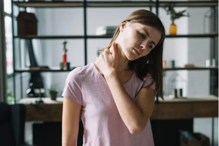 Young woman holding the side of her neck in discomfort