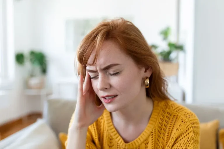 Woman holding her head with her eyes closed