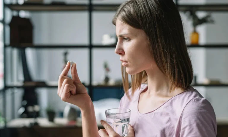 Young woman holding a tablet and a glass of water