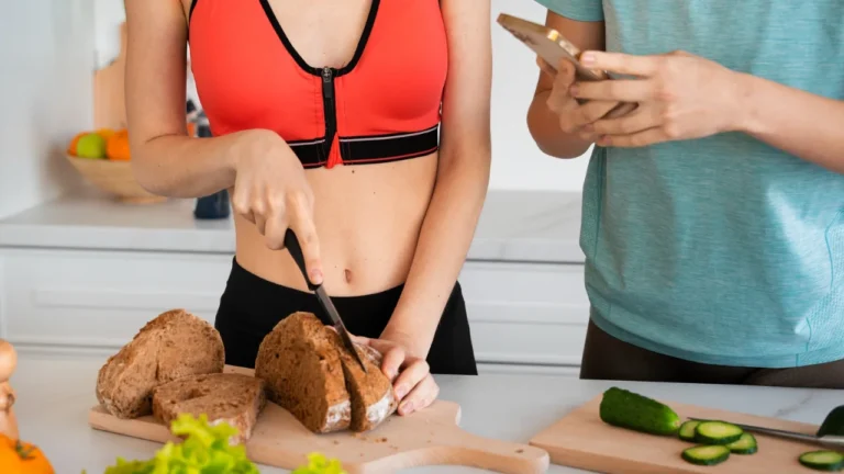 Woman preparing vegetables in a kitchen while another person points