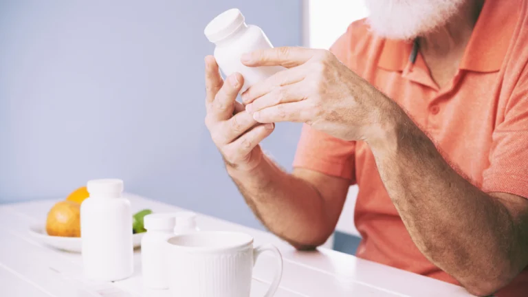 Older man reading the label on a supplement bottle