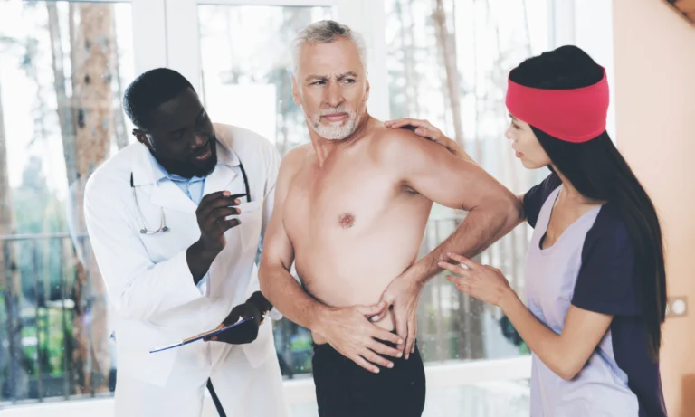 Two clinicians examining a shirtless older man