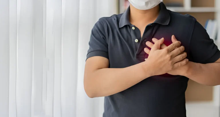 Masked man holding his hand against his chest
