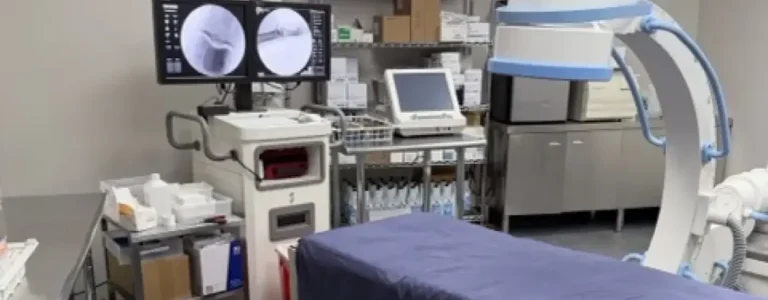 Fluoroscopy suite with C-arm and procedure table at Padda Institute, St. Louis