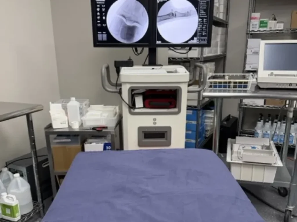 Fluoroscopy procedure room with live imaging monitors at Padda Institute, St. Louis