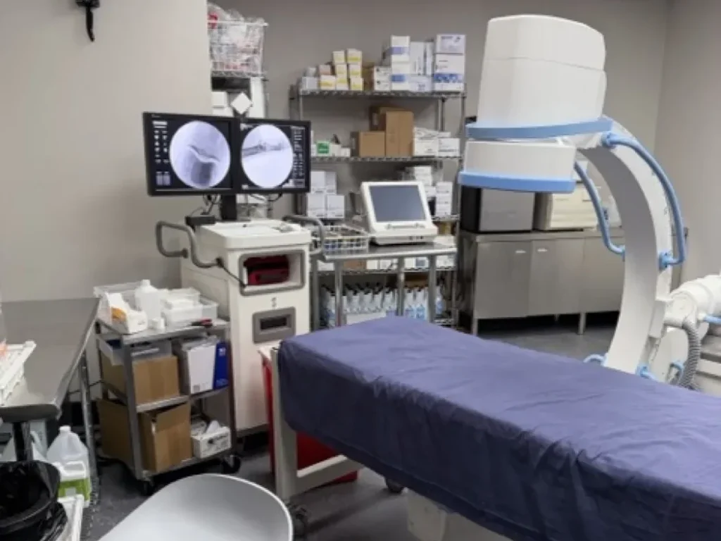 Fluoroscopy suite with C-arm and procedure table at Padda Institute, St. Louis