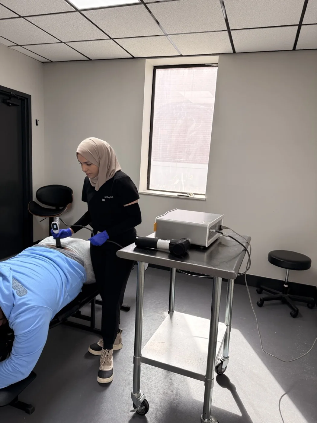 Clinician delivering shockwave therapy to a patient in a treatment room at Padda Institute, St. Louis