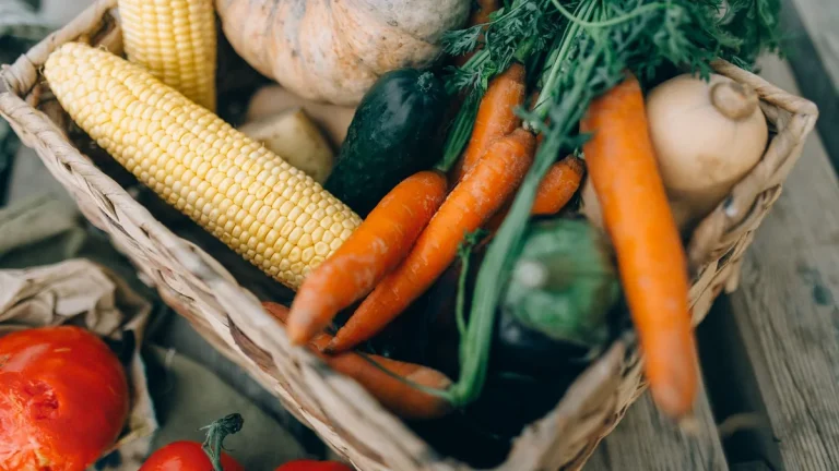 A close-up of fresh organic vegetables in a wicker basket.