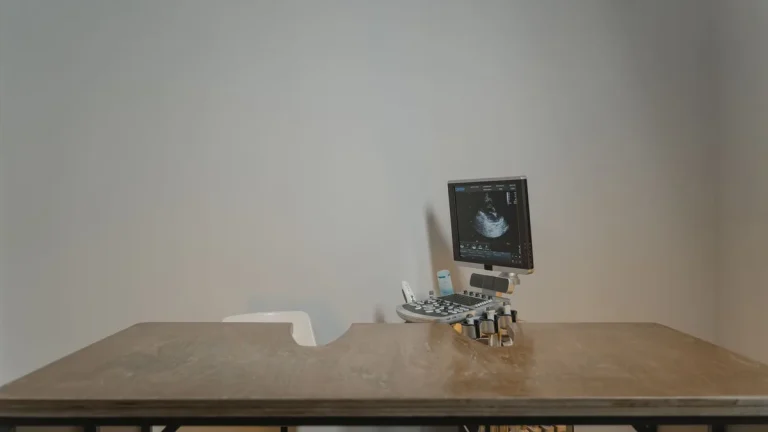 Ultrasound machine setup in a minimalist medical office for patient examinations.