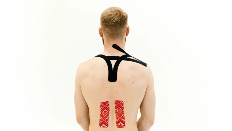 Man with kinesio tape on his back for muscle support and pain relief.
