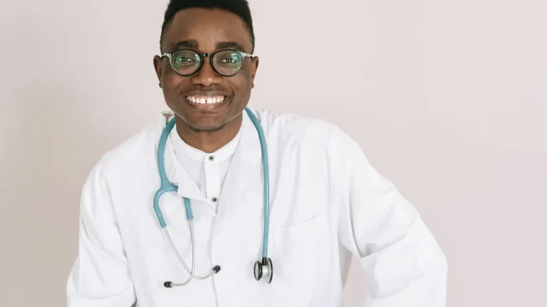 Cheerful male doctor wearing eyeglasses and a stethoscope, illustrating health care professionalism.