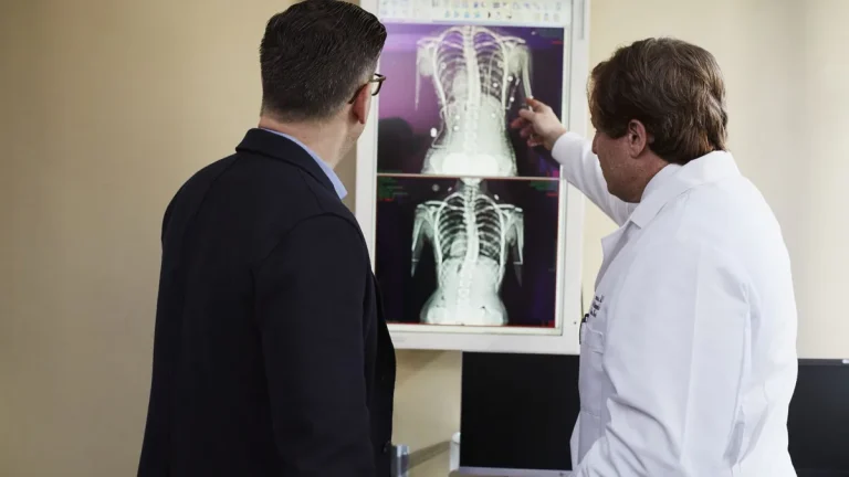 A doctor explains X-ray results to a patient in a clinical setting.
