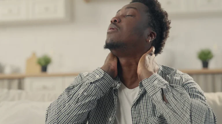 Man holding the back of his neck in discomfort