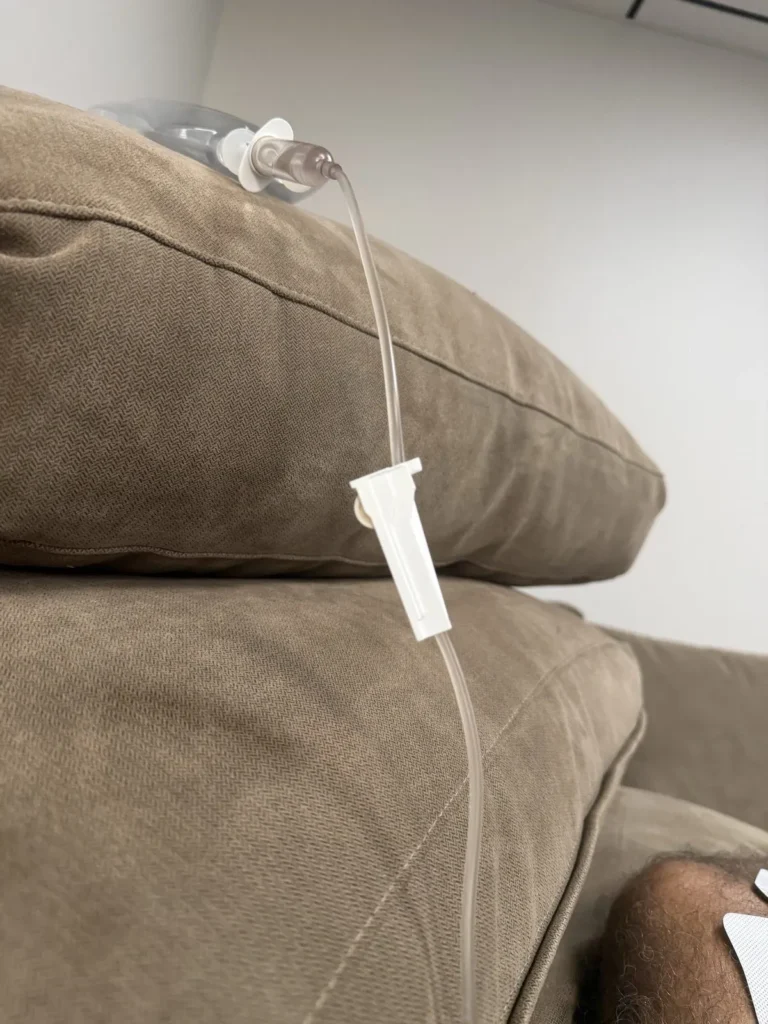 IV fluid bag and tubing resting on a couch cushion