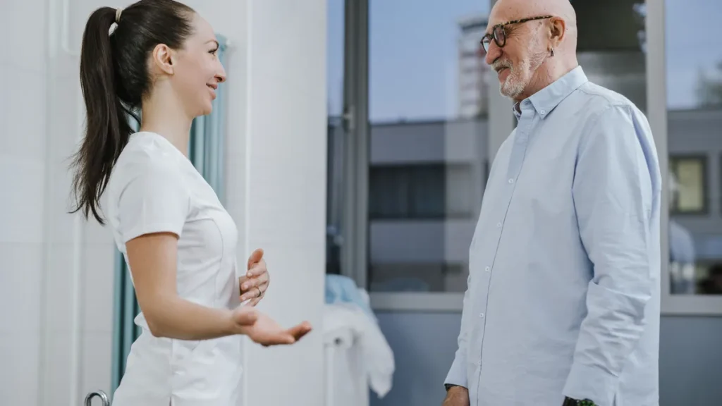 An older man talks with a clinician during a pain appointment