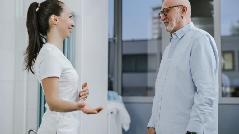 An older man talks with a clinician during a pain appointment